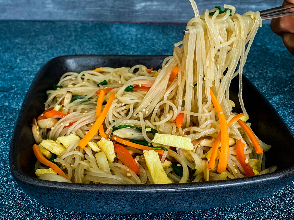 Japchae Noodles - a Korean glass noodle dish with a medley of veggies and egg tossed in a tasty sauce.